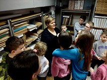 Na zdjęciu pani Ania prezentuje dzieciom najciekawsze książki w magazynie Biblioteki Głównej