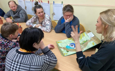 Bibliotekarka czyta uczestinkom zajęć książkę