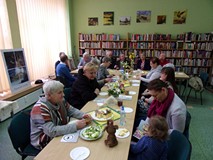 na zdjęciu zebrali siedzą przy stołach i rozmawiają