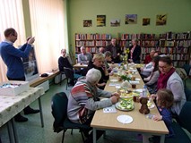 na zdjęciu zebrali siedzą przy stołach i rozmawiają