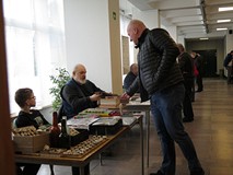 Uczestnik Giełdy Kolekcjonerskiej ogląda eksponaty kolekcjonera.