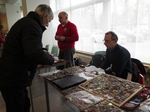 Uczestnik Giełdy Kolekcjonerskiej ogląda eksponaty kolekcjonera.