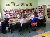 na zdjęciu zebrali siedzą przy stole i dyskutują