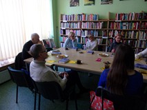 na zdjęciu zebrali siedzą przy stole i dyskutują