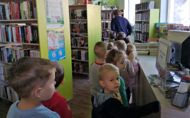 Dzieci wędrują gęsiego po bibliotece