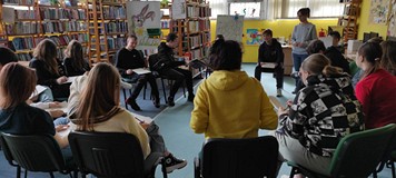 bibliotekarka z dziećmi bawi sie w gluchy telefon