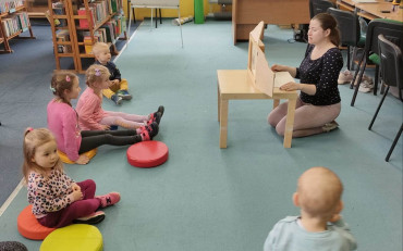 bibliotekarka czyta dzieciom opowiadanie z teatrzyku kamishibai