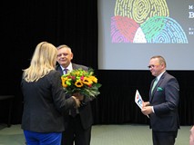 Prezydent Piotr Jedliński wręcza kwiaty pani dyrektor w czasie Dnia Bibliotekarza w Koszalińskiej Bi