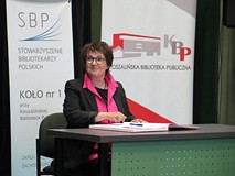 Zasłużona bibliotekarka składa podpis w Księdze zasłużonych w czasie Dnia Bibliotekarza w Koszalińsk