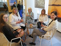 Bibliotekarki siedzą przy kawie i ciastku w czasie Dnia Bibliotekarza w Koszalińskiej Bibliotece Pub