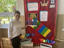 Bibliotekarka zawiesza plakat promujący Tydzień Bibliotek