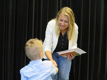 Pani dyrektor wręcza dyplom i nagrodę uczestnikowi finału powiatowego przeglądu recytatorskiego dla 