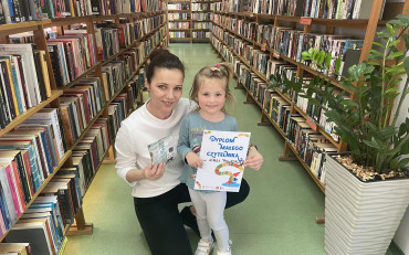 Dziewczynka z bibliotekarką prezentują dyolom