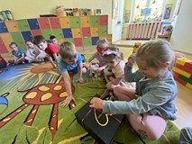 Dzieci otwierają paczkę przygotowaną dla nich przez bibliotekarkę