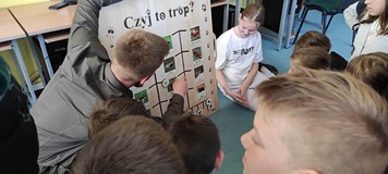 Dzieci pokazują tropy zwierząt na tablicy edkukacyjnej