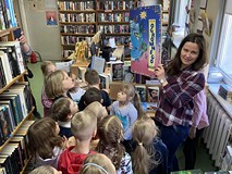 Bibliotekarka pokzauje dzieciom największą książkę