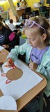 dzieci wykonują przy stole pracę plastyczną