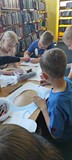 dzieci wykonują przy stole pracę plastyczną