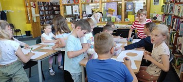 dzieci wykonują przy stole pracę plastyczną