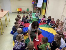 Bibliotekarka rozdaje dzieciom karteczki
