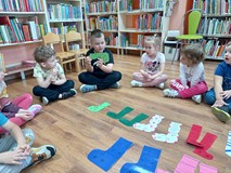 Przedszkolak czyta jedną z historii i przygód skarpetki