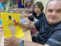 Uczestnik pokazuje pracę plastyczną