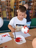 chłopiec wykonuje pracę plastyczną