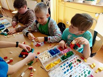 Na zdjęciu uczestnicy warsztatów budują z klocków LEGO średniowieczne warownie