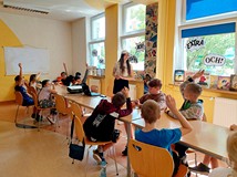 Na zdjęciu uczestnicy warsztatów budowania z klocków LEGO oraz prowadząca