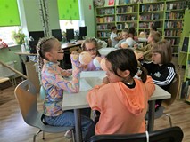 Dzieci malują farbkami głowy przyszłych lalek