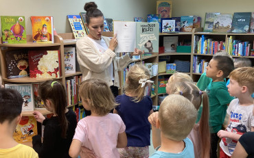 Bibliotekarka prezentuje dzieciom książkę