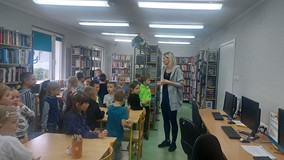 Bibliotekarka oprowadza uczniów po bibliotece