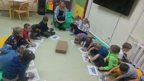 Dzieci wykonuja zadanie na kartkach