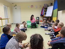 Bibliotekarka prezentuje dzieciom książkę