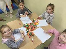 Dzieci podczas zajęć przy stolikach wykonują pracę plastyczną