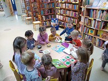 Dzieci w czytelni oglądają książki