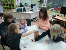 Uczestniczki spotkania i bibliotekarka podczas gry w BECZKĘ ŚMIECHU