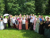 Uczestnicy Narodowego Czytania Nad Niemnem w parku przy bibliotece