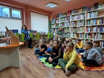Uczniowie słuchają i oglądają teatrzyk kamishibai