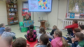 Bibliotekarka pokazuje uczniom mapę