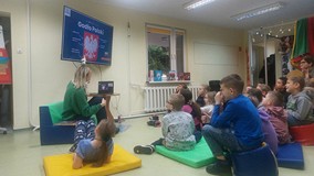Uczniowie oglądają na monitorze godło Polski