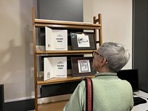 Uczestniczka wydarzenia podczas oglądania prac.