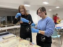 Uczestniczki warsztatów podczas tworzenia papieru marmurkowego.