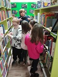 Bibliotekarka oprowadza dzieci po bibliotece