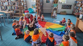 bibliotekarka rozdaje dzieciom dzwonki