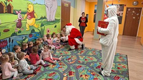 bałwan z Mikołajem czytają książkę dzieciom