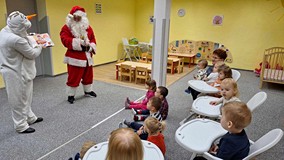 bałwan z Mikołajem czytają książkę dzieciom