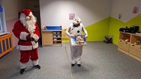 bałwan z Mikołajem czytają książkę dzieciom