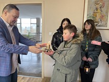 Harcerz przekazuje Światełko Betlejemskie dyrektorowi KBP