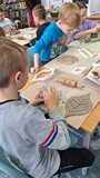 dzieci wykonują pracę plastyczną z gliny